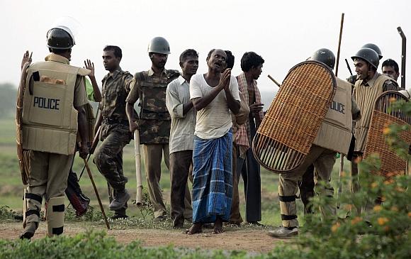 A villager begs a policeman to spare him after his arrest near Lalgarh, West Bengal