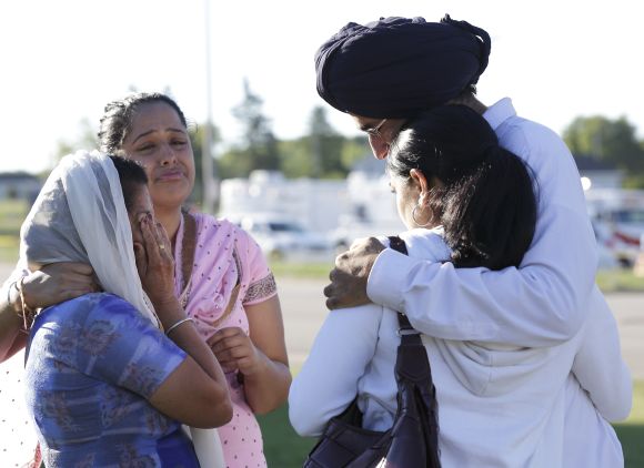 Mourners cry outside the scene of a mass shooting at a gurdwara in Oak Creek, Wisconsin, on Sunday where six people were shot dead.