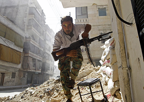 a Free Syrian Army fighter takes cover during clashes with Syrian army in the Salaheddine neighbourhood of central Aleppo