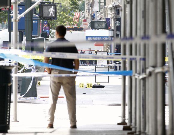 A New York City Police investigator stands at the scene of a shooting outside the Empire State Building in New York on Friday