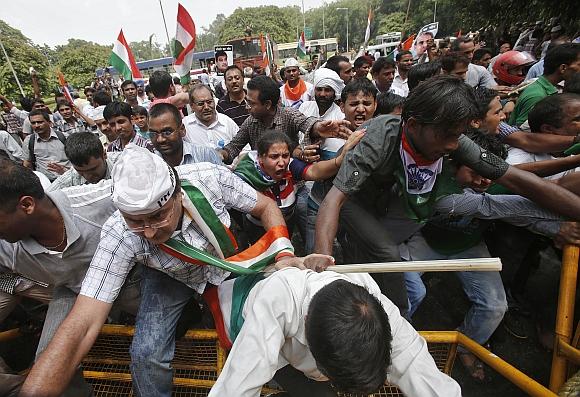 Supporters of veteran Indian social activist Anna Hazare climb over a police barricade during a protest against corruption near the residence of Prime Minister Manmohan Singh in New Delhi