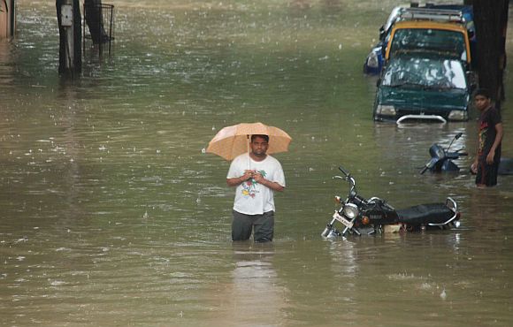 A man makes him way through a flooded street in Hindmata locality