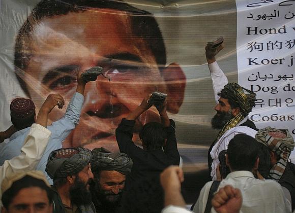 Men place slippers on an image United States President Barack Obama during an anti-US demonstration in Quetta