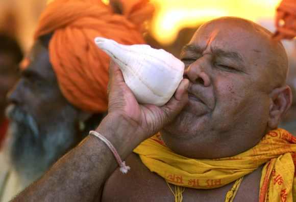 A Hindu priest blows a conch shell in Ayodhya