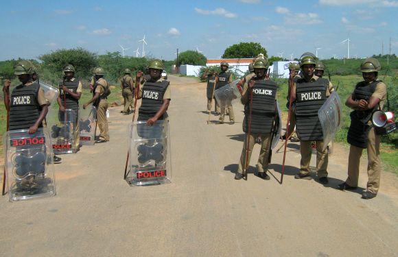 Policemen in riot gear wait outside Idinthakarai village