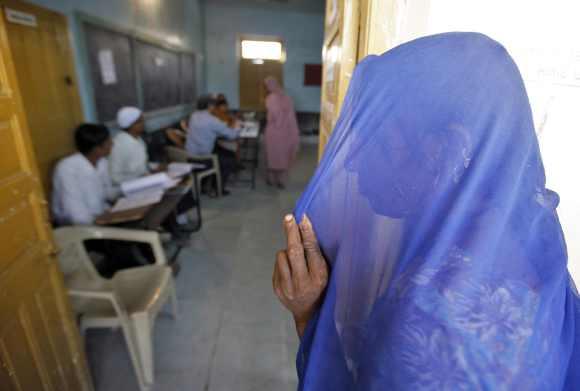 A voter stands in a queue to cast her ballot in the first phase of Gujarat elections