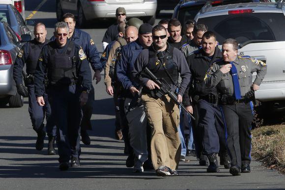 Police patrol the streets outside Sandy Hook Elementary School after a shooting in Newtown, Connecticut.