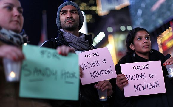 People hold a candlelight vigil in Times Square, for the victims of the Sandy Hook School shooting, in New York