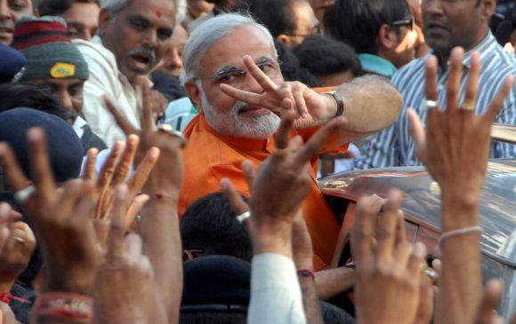 Narendra Modi flashes a 'V Sign' after casting his vote in Ranip, Ahmedabad, on Monday