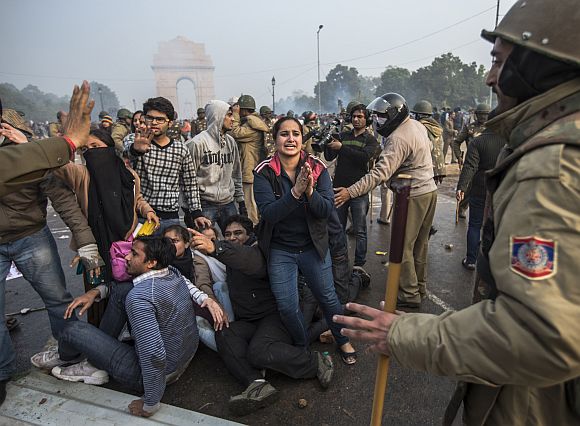 A protestor begs for mercy as Delhi Police lathi charge during the protest at Raisina Hill