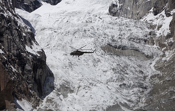 A military helicopter carrying Pakistani President Asif Ali Zardari and Army Chief General Ashfaq Kayani, and other officials fly over the site of an avalanche over Gayari camp near the Siachen glacier