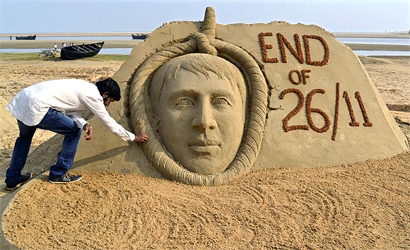 Indian sand artist Sudarshan Patnaik gives the final touches to a sand sculpture of Mohammad Ajmal Kasab on a beach in Odisha