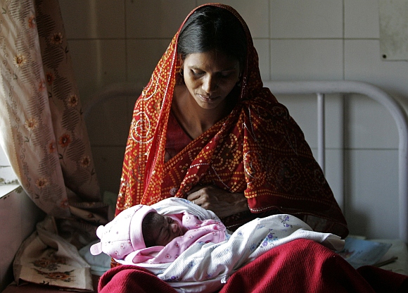 A mother holds her newborn baby girl inside a community health centre in Mall, on the outskirts of Lucknow