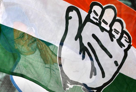 A cut out of Indian Prime Minister Manmohan Singh is seen through the Congress party flag
