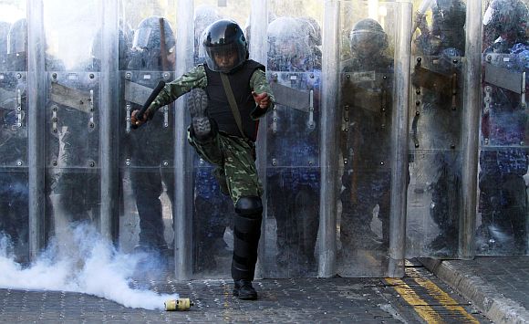 An army officer kicks a tear gas cannister during a clash with the supporters of ousted Maldivian president Mohamed Nasheed in Male