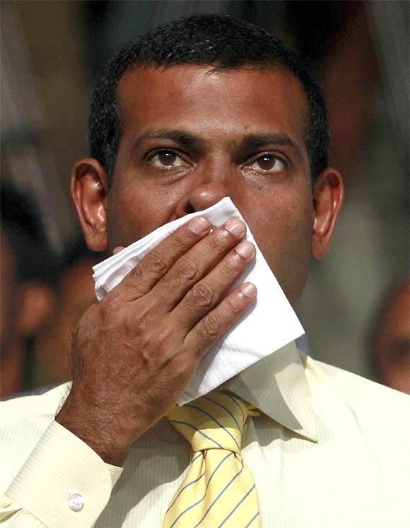 Former Maldivian president Mohamed Nasheed wipes his face during a Maldivian Democratic party meeting in Male