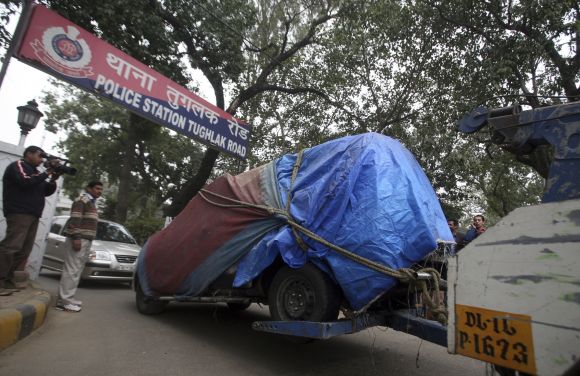 A covered damaged Israeli embassy car is towed away from a police station to another police station in New Delhi