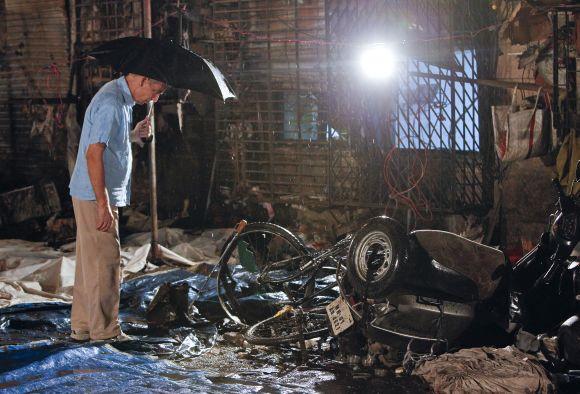 A plain-clothed policeman surveys the aftermath at the site of an explosion near the Opera House in Mumbai