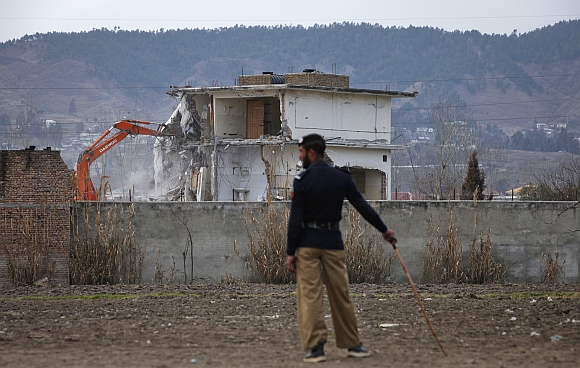 A policeman looks on as the building is demolished in Abbottabad