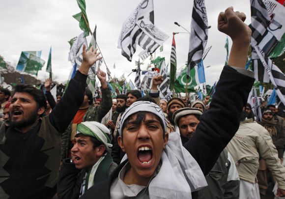 A supporter of a religious and political party chants slogans with hundreds of others during an anti-US rally organized by the Difa-e-Pakistan Council in Islamabad