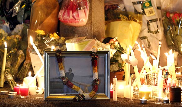 Candles stand alongside a photograph of Anuj Bidve