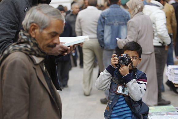 Hashim, 8, takes pictures at al-Mutanabi street in Baghdad