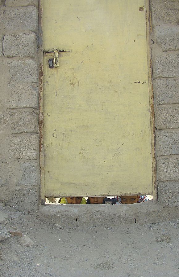 Children peek out from the doorway of their makeshift house in the city of Kut, 150 km (95 miles) southeast of Baghdad in this 2009 photo