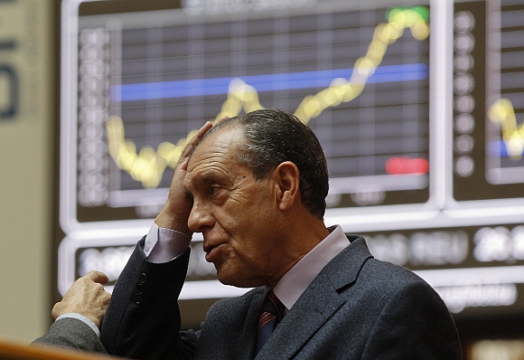 A man holds his head at the bourse in Madrid. European stock futures pointed to a weaker open for equities on Monday as political uncertainties in highly-indebted Italy and Greece raised fresh concerns that the region's debt crisis would intensify and threaten a fragile global economic recovery.