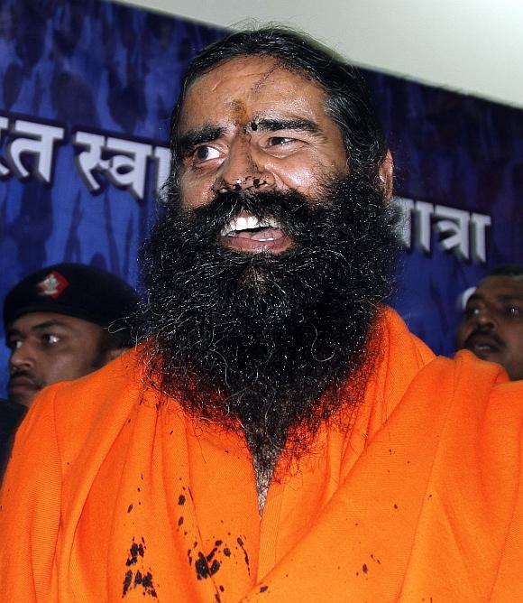 Ramdev reacts with his face smeared with black ink after addressing a news conference in New Delhi