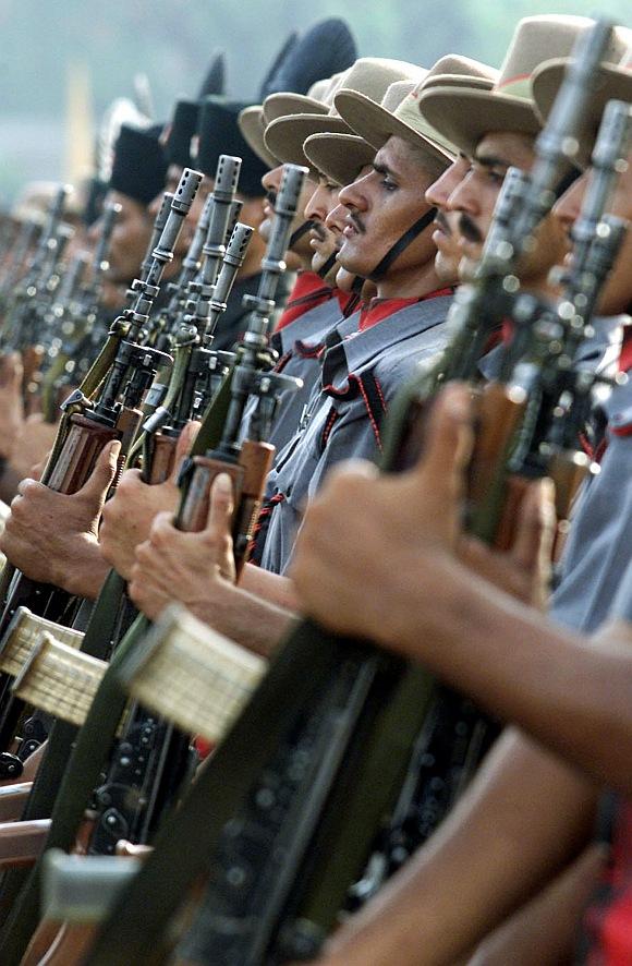 New recruits of the Assam Rifles stand at attention during their joint passing-out parade with the Rajputana Rifles in New Delhi.