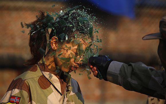 An instructor from the Tianjiao Special Guard/Security Consultant Ltd. Co, smashes a bottle over a female recruit's head during a training session for China's first female bodyguards in Beijing