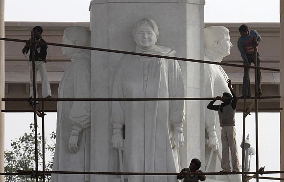 Workers erect a scaffolding to cover statues of Uttar Pradesh Chief Minister Mayawati in Lucknow