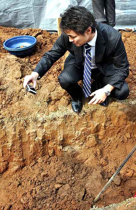 An official photographs one the dug up graves
