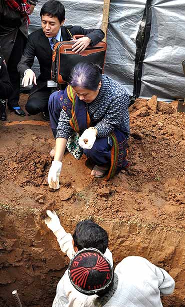 An official collects remains dug out from the Guwahati war cemetery