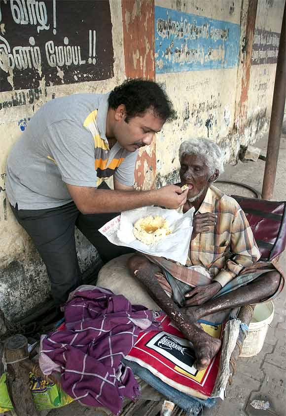 Narayanan Krishnan feeds a mentally ill man in Madurai