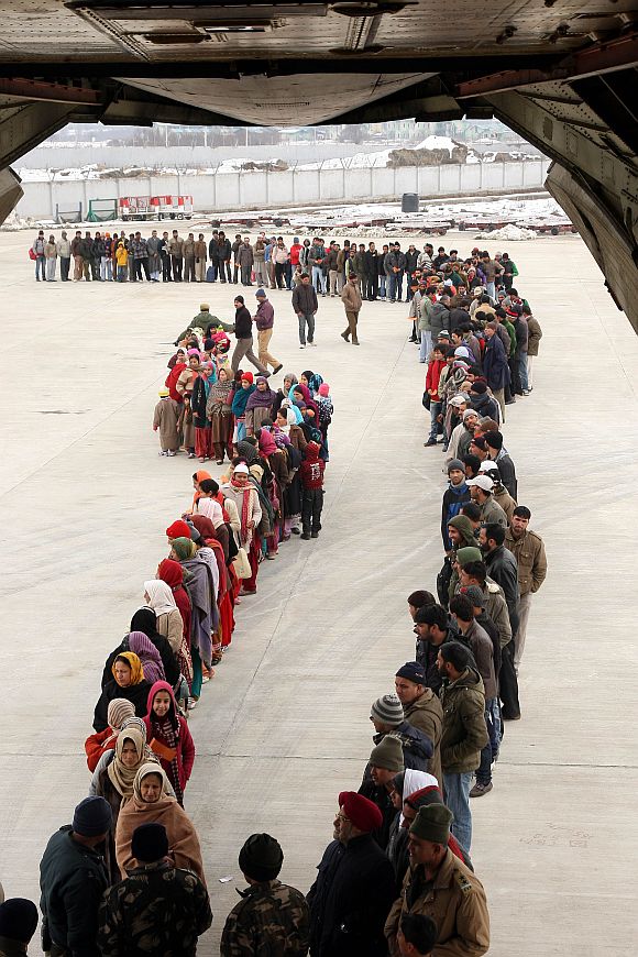Civilians wait to be airlifted at the Jammu air base