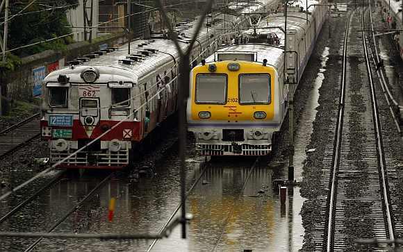 Trains move through flooded tracks after heavy rains in Mumbai