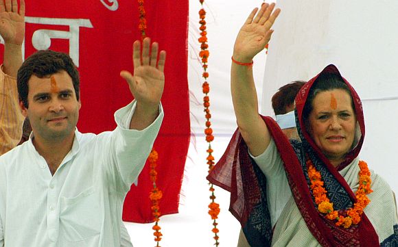 Rahul Gandhi and Congress president Sonia Gandhi wave to supporters during a rally in Rae Bareli