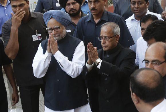 Prime Minister Manmohan Singh and newly elected President Pranab Mukherjee gesture to the media outside the latter's residence in New Delhi on Sunday