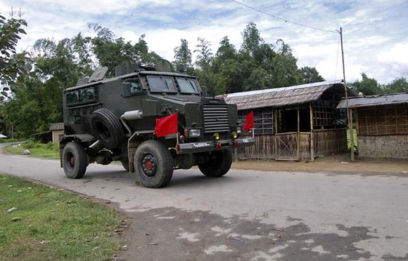 An army bullet-proof vehicle patrols through a street during curfew near Kokorajhar town in Assam