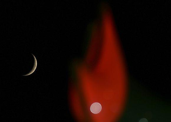 The moon (top left) is seen among illuminated decorations near al Amin mosque in Beirut, during the holy month of Ramzan