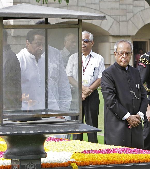 Newly elected President Pranab Mukherjee walks after paying respect at the Mahatma Gandhi memorial at Rajghat in New Delhi