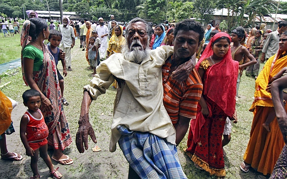 Jahar (centre), a 105-year-old villager affected by ethnic riots, is carried by his son to a relief camp near Bijni