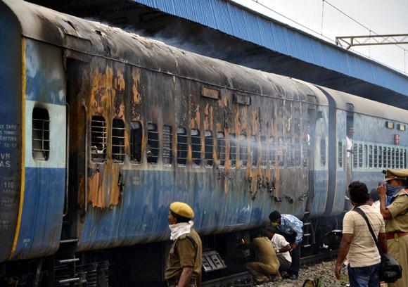 A burnt carriage of a passenger train is pictured at the Nellore railway station, Andhra Pradesh