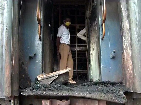 A rescue worker carries on a relief operation inside a damaged compartment of the train