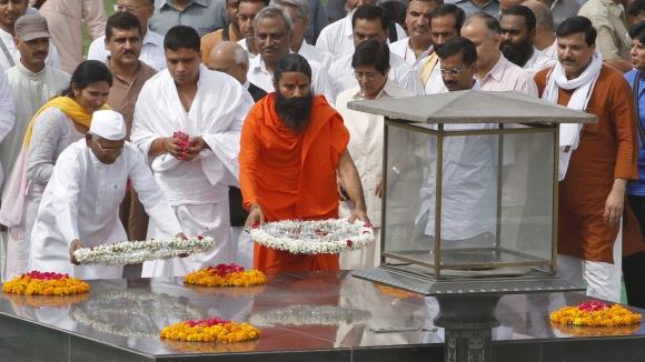 Ramdev and Anna Hazare place wreaths at the Mahatma Gandhi memorial at Rajghat