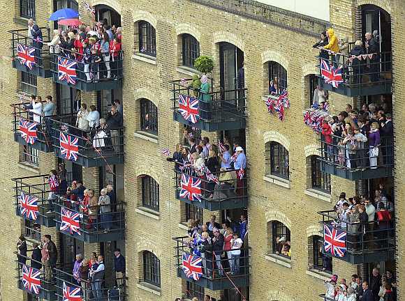 Spectators watch from Butlers Wharf, near Tower Bridge, during Queen Elizabeth's Diamond Jubilee River Pageant along the River Thames