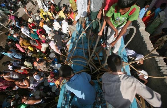 Residents fill their containers with drinking water from a water tanker provided by the state-run Delhi Jal Board in New Delhi