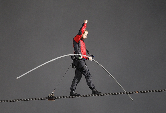 Nik Wallenda pumps his fist as he reaches the end of his tight rope walk