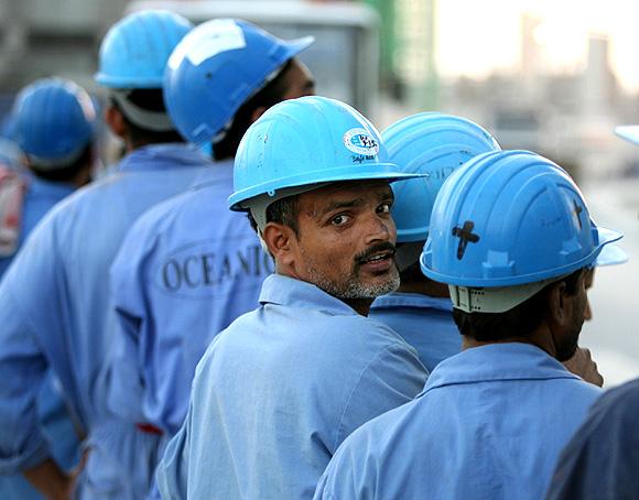 Indian workers line up to board a bus after a day's work in Dubai